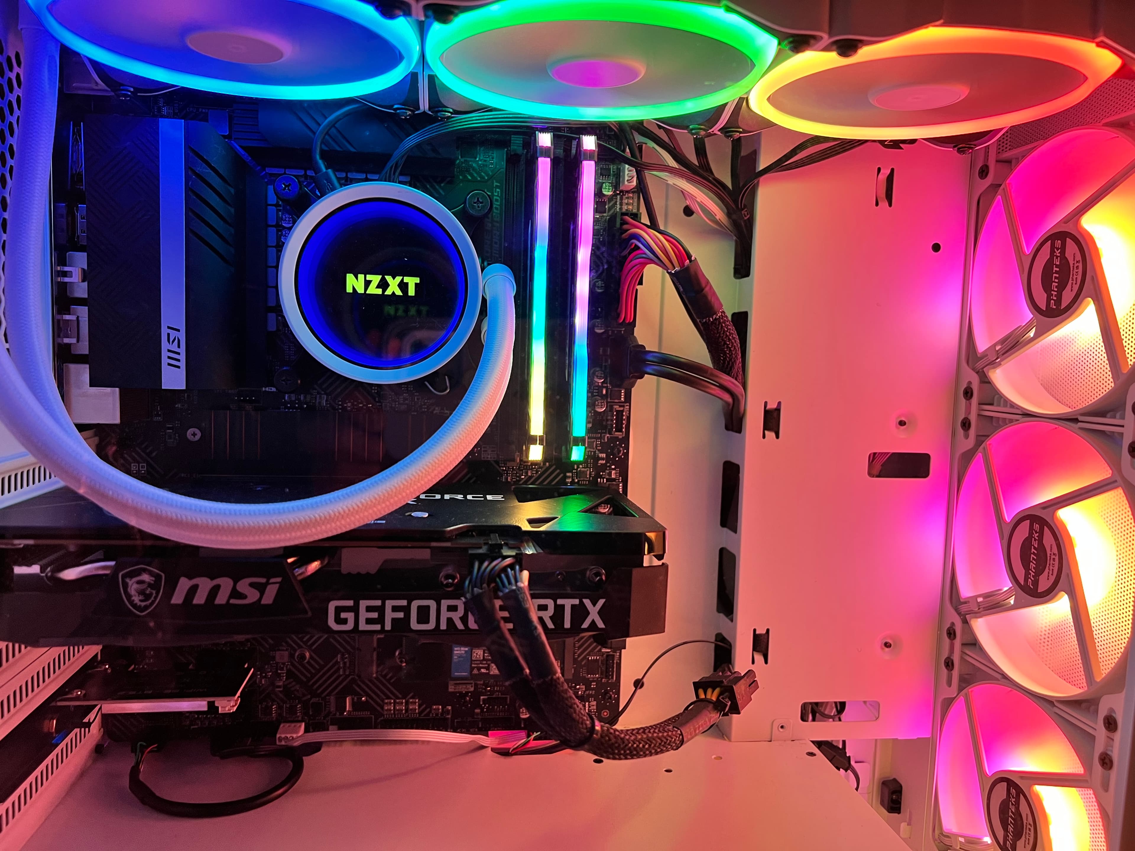 The inner parts of my PC build featuring the AIO/Radiator, motherboard, memory, GPU and some messy cables.